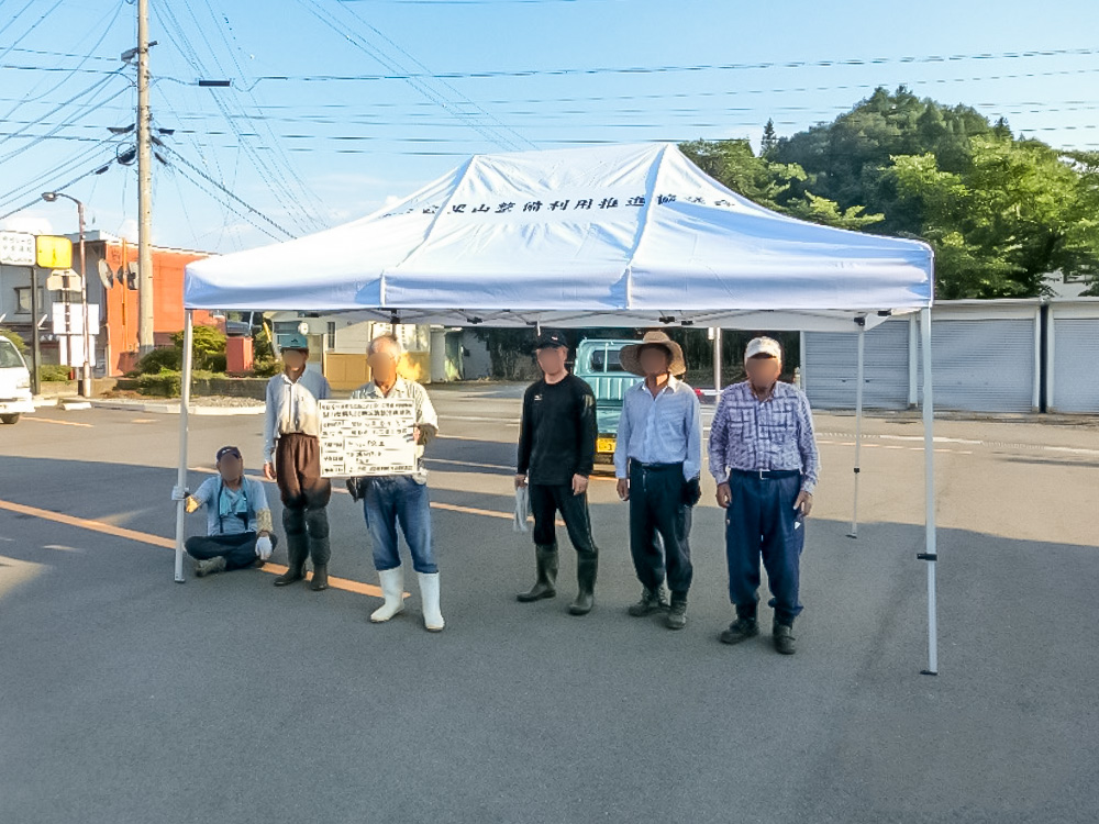 組み立てたミスタークイックテントの前に並ぶ協議会の皆さん（長野県）