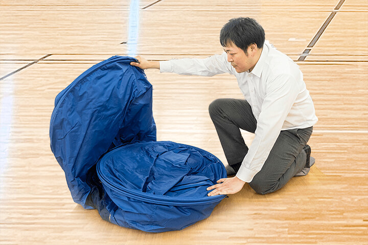 折りたたんだ避難用テントを広げている様子