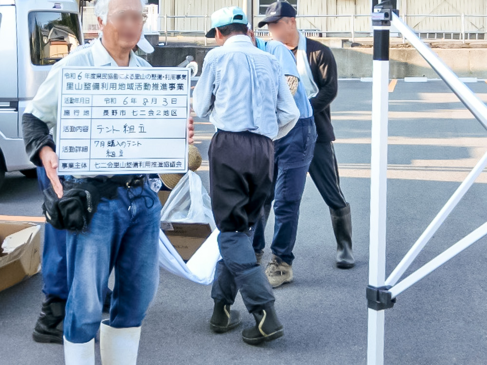 組み立てたテントの前で看板を持つ皆さん（長野県）